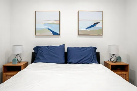 a bedroom with bed and painting on the wall