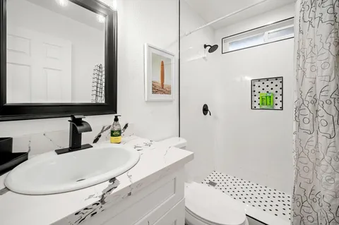 a bathroom with a sink toilet and shower