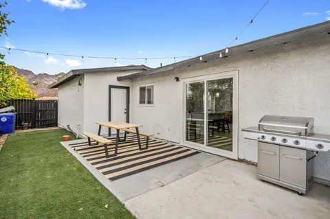 a backyard of a house with barbeque oven and outdoor seating