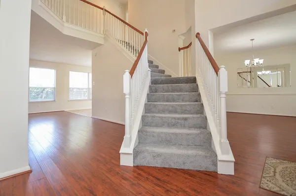 a view of staircase with white walls and wooden floor