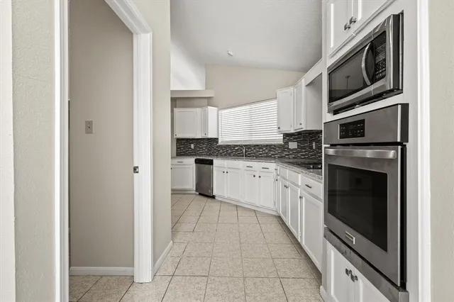 a kitchen with stainless steel appliances granite countertop a refrigerator and a stove top oven