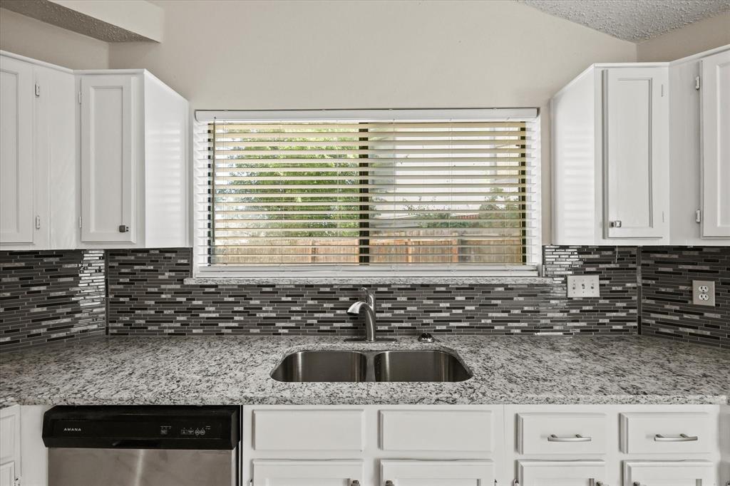 1113 Kit Lane Plano, TX 75023 - Photo 15 of 31 a kitchen with granite countertop a sink and a white wooden cabinets