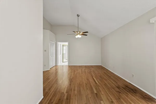 a view of a room with wooden floor and ceiling fan
