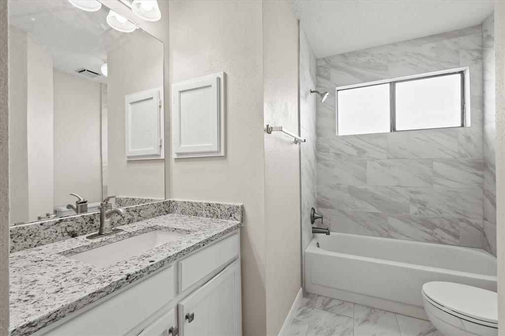1113 Kit Lane Plano, TX 75023 - Photo 24 of 31 a bathroom with a granite countertop sink mirror toilet and bathtub