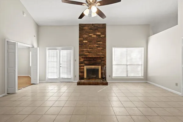 a view of an empty room with a fireplace and a window