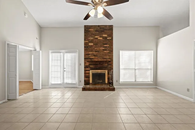 a view of an empty room with a fireplace and a window