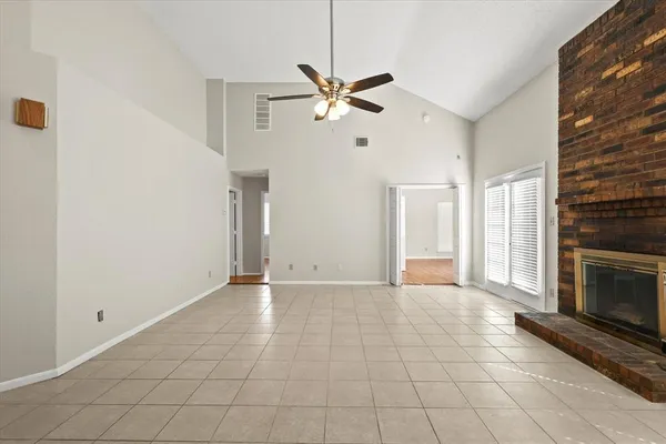 a view of an empty room with window and fireplace