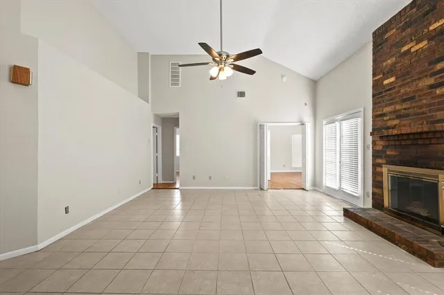 a view of an empty room with window and fireplace
