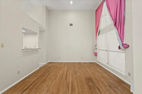 a view of a room with wooden floor and window