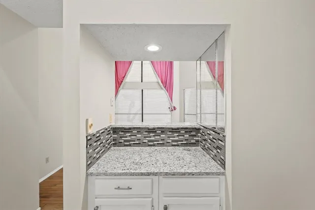 a bathroom with a granite countertop sink and a window