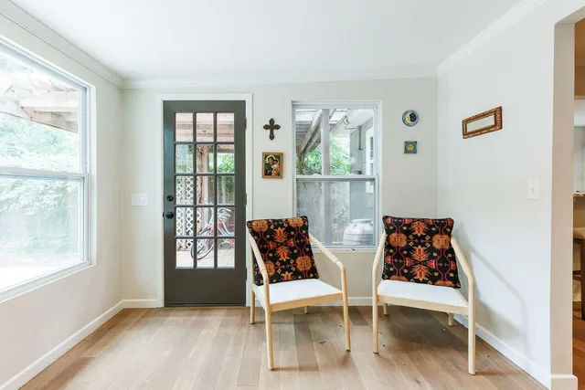 a living room with furniture a wooden floor and next to a window