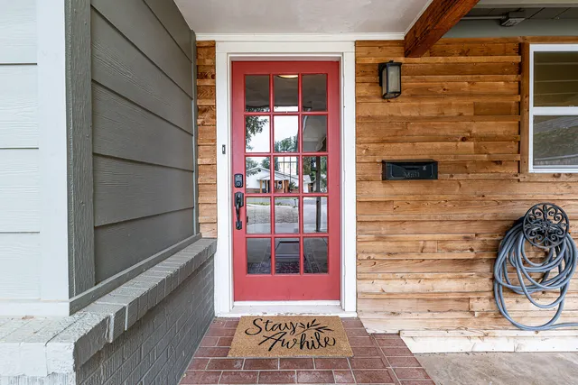 a view of a hallway to a livingroom with wooden floor and a chandelier
