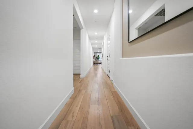 a view of a hallway with wooden floor