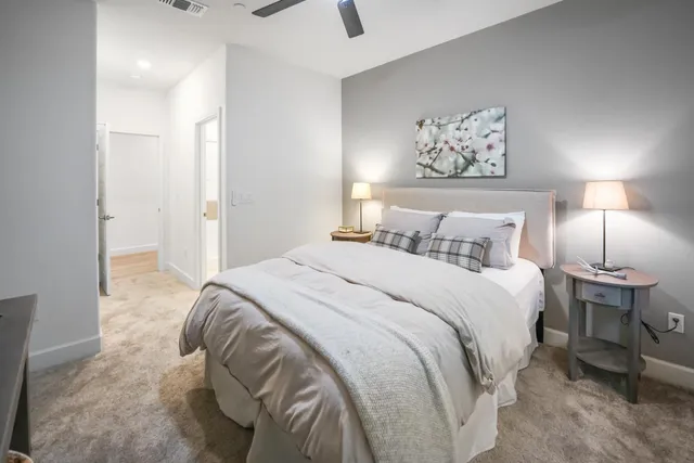 a bedroom with a bed and a lamp on dresser