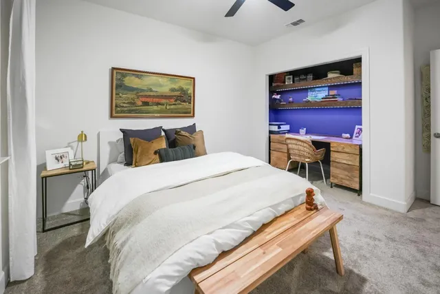 a bedroom with a bed and a desk