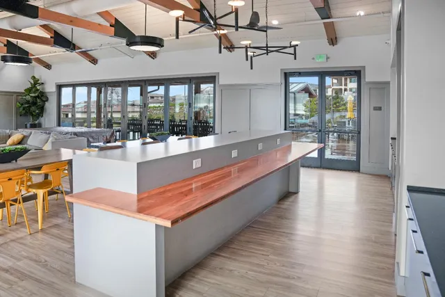 a large white kitchen with a large window a sink and stainless steel appliances