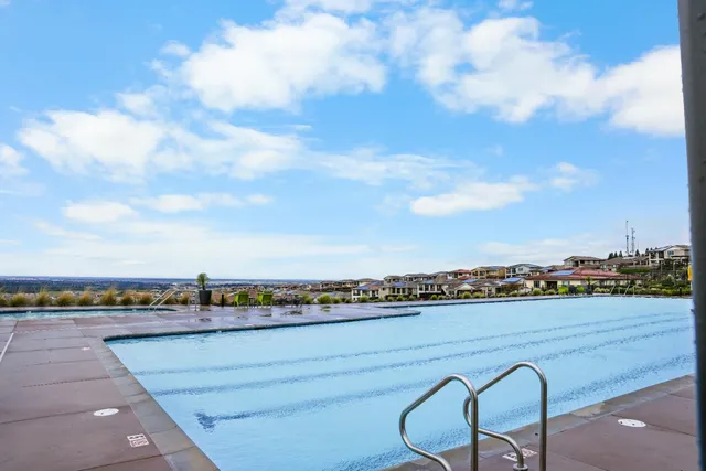 a large white kitchen with a large window a sink and stainless steel appliances