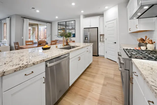 a kitchen with stainless steel appliances granite countertop a sink stove and refrigerator