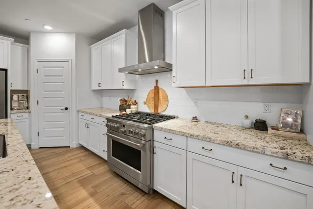 a kitchen with granite countertop white cabinets and appliances