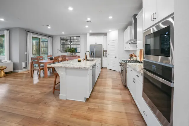 a large kitchen with stainless steel appliances kitchen island granite countertop a large counter top and stainless steel appliances