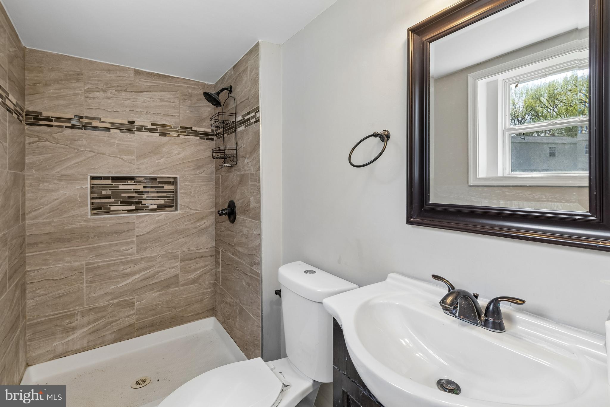 5903 Sylvia Court Clinton, MD 20735 - Photo 13 of 21 a bathroom with a sink a mirror a toilet and shower