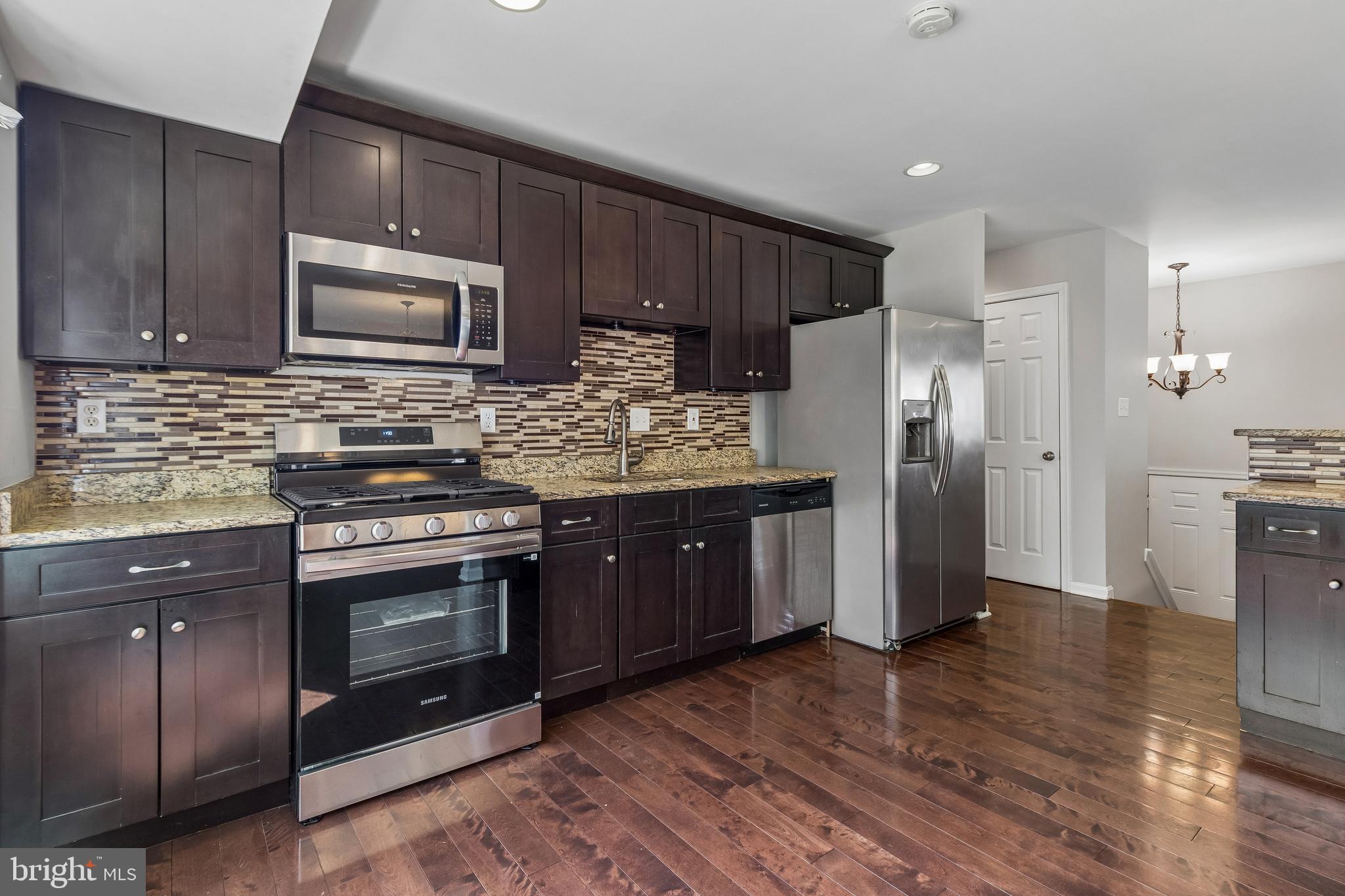 5903 Sylvia Court Clinton, MD 20735 - Photo 2 of 21 a kitchen with stainless steel appliances granite countertop a stove a refrigerator and a microwave oven