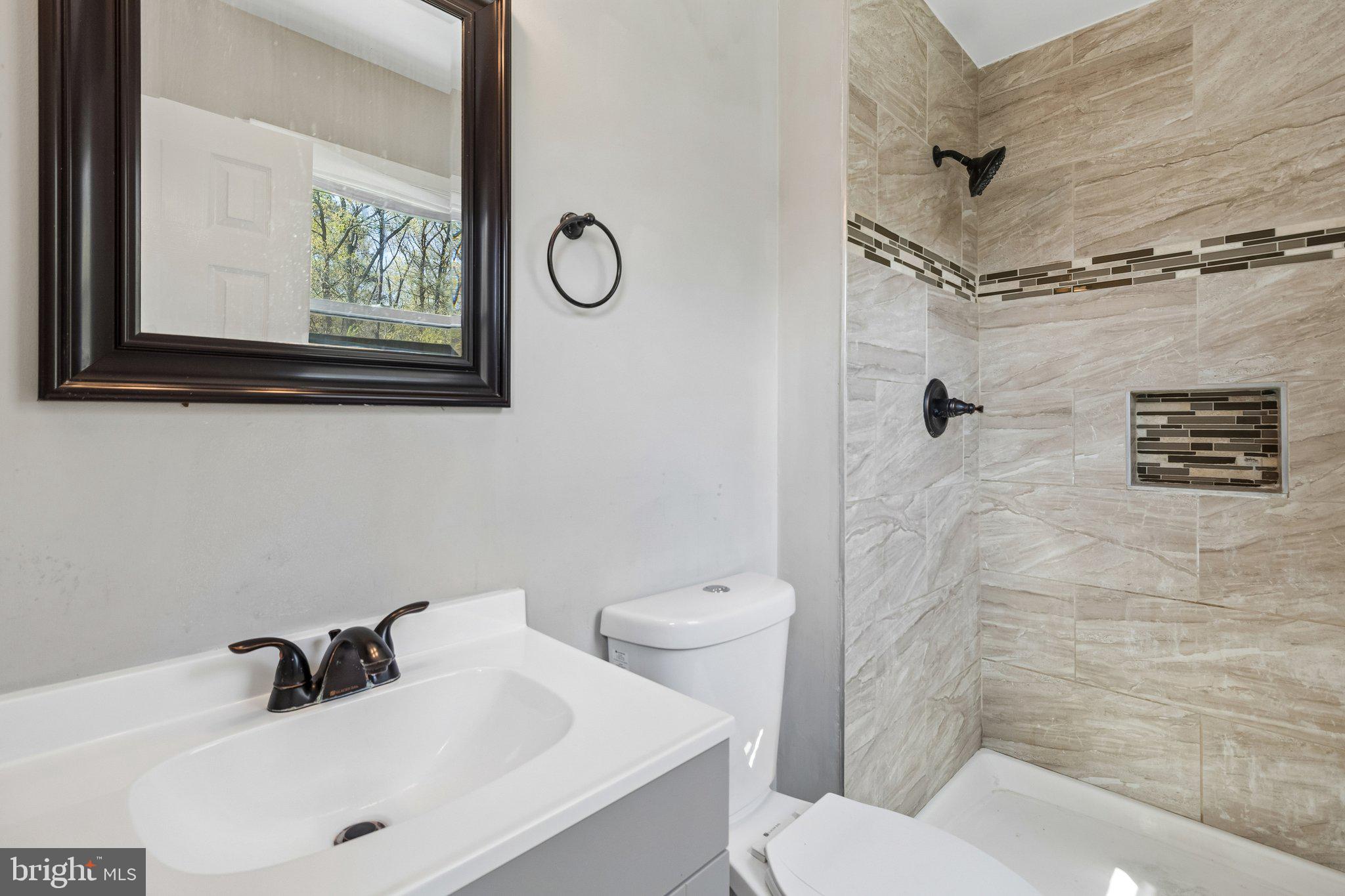 5903 Sylvia Court Clinton, MD 20735 - Photo 10 of 21 a bathroom with a sink a mirror and a toilet