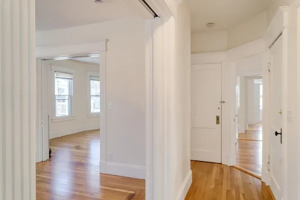 a view of a hallway with wooden floor