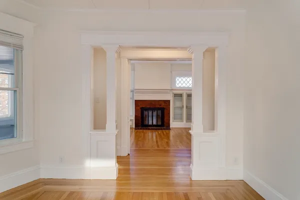a view of a livingroom with wooden floor and a fireplace
