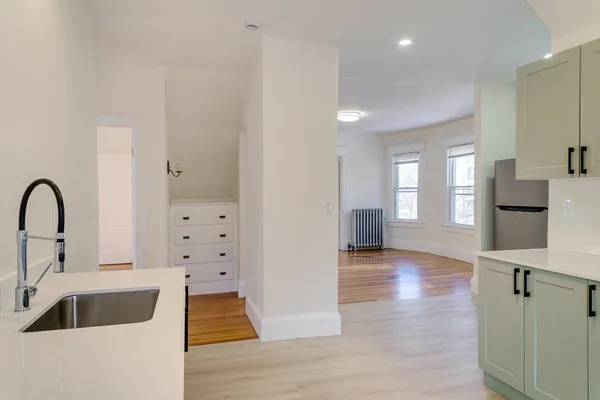 a kitchen with kitchen island a counter top space appliances and a sink