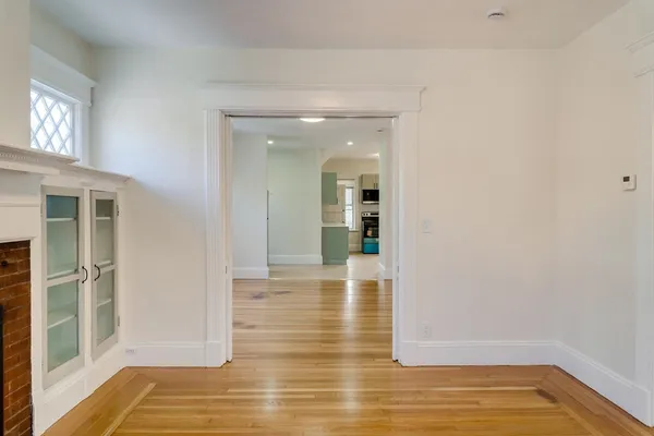 a view of empty room with wooden floor and windows