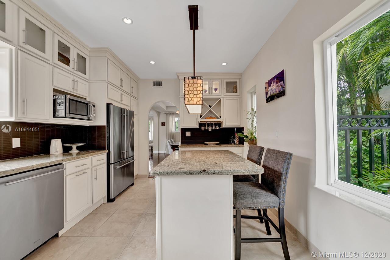 2203 North Bay Road Miami Beach, FL 33140 - Photo 12 of 36 a kitchen with stainless steel appliances granite countertop a stove top oven a sink dishwasher and a refrigerator with wooden floor