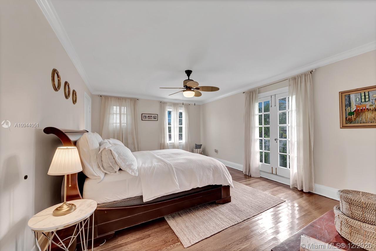 2203 North Bay Road Miami Beach, FL 33140 - Photo 17 of 36 a bedroom with a bed and a chandelier