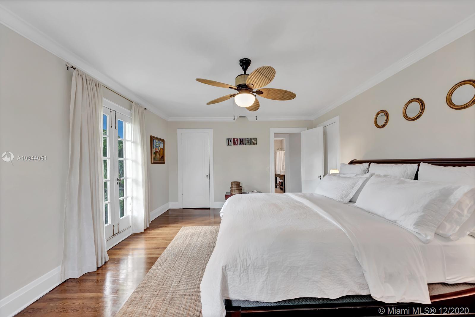 2203 North Bay Road Miami Beach, FL 33140 - Photo 18 of 36 a bedroom with a bed and a chandelier