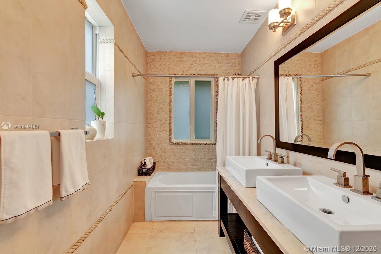 2203 North Bay Road Miami Beach, FL 33140 - Photo 19 of 36 a bathroom with a double vanity sink a mirror and a bathtub