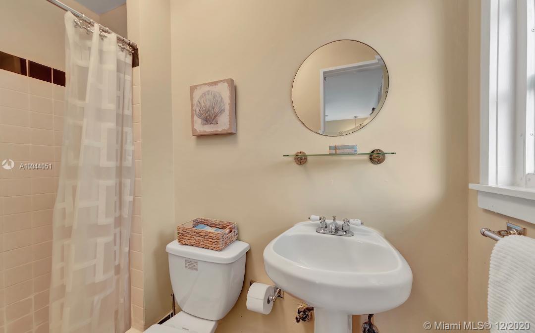 2203 North Bay Road Miami Beach, FL 33140 - Photo 27 of 36 a bathroom with a sink a mirror and a toilet