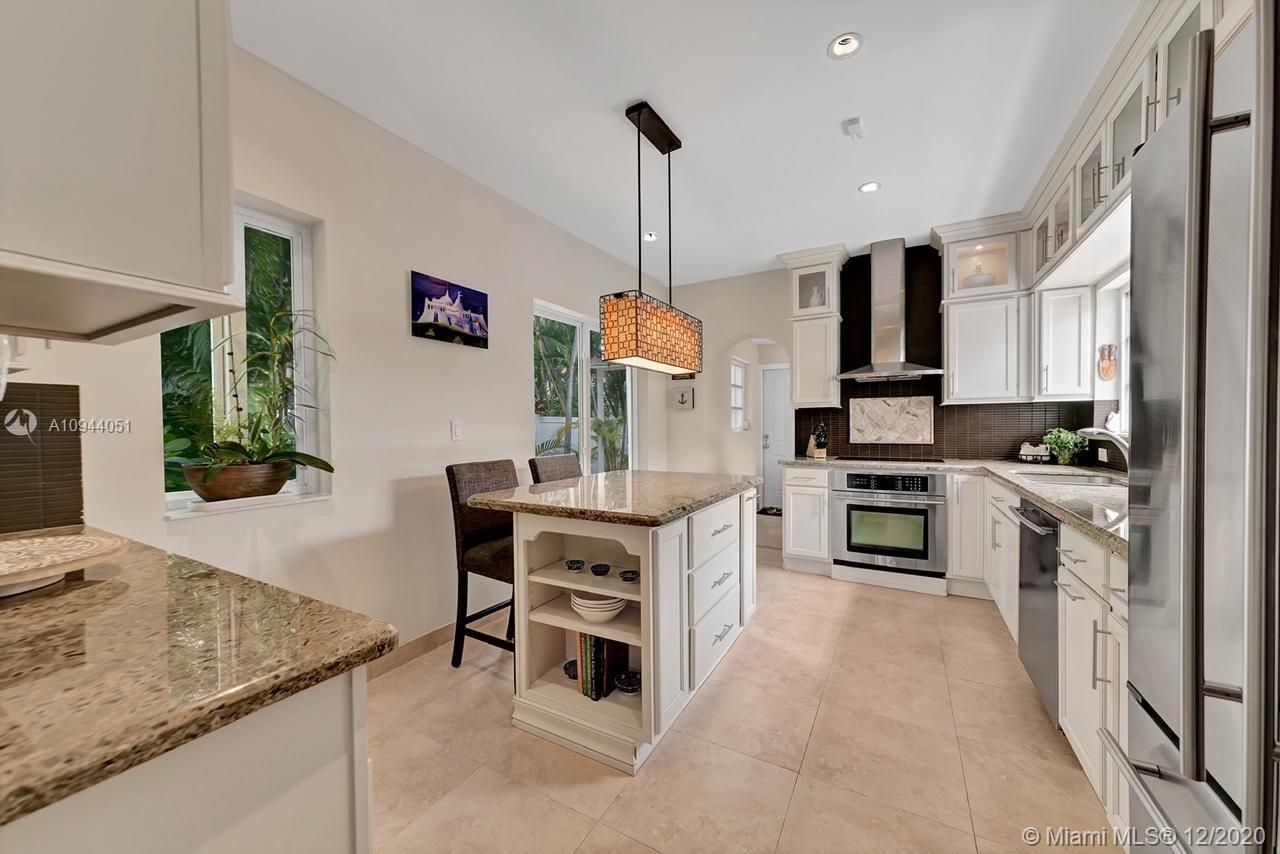 2203 North Bay Road Miami Beach, FL 33140 - Photo 10 of 36 a kitchen with white cabinets and stainless steel appliances