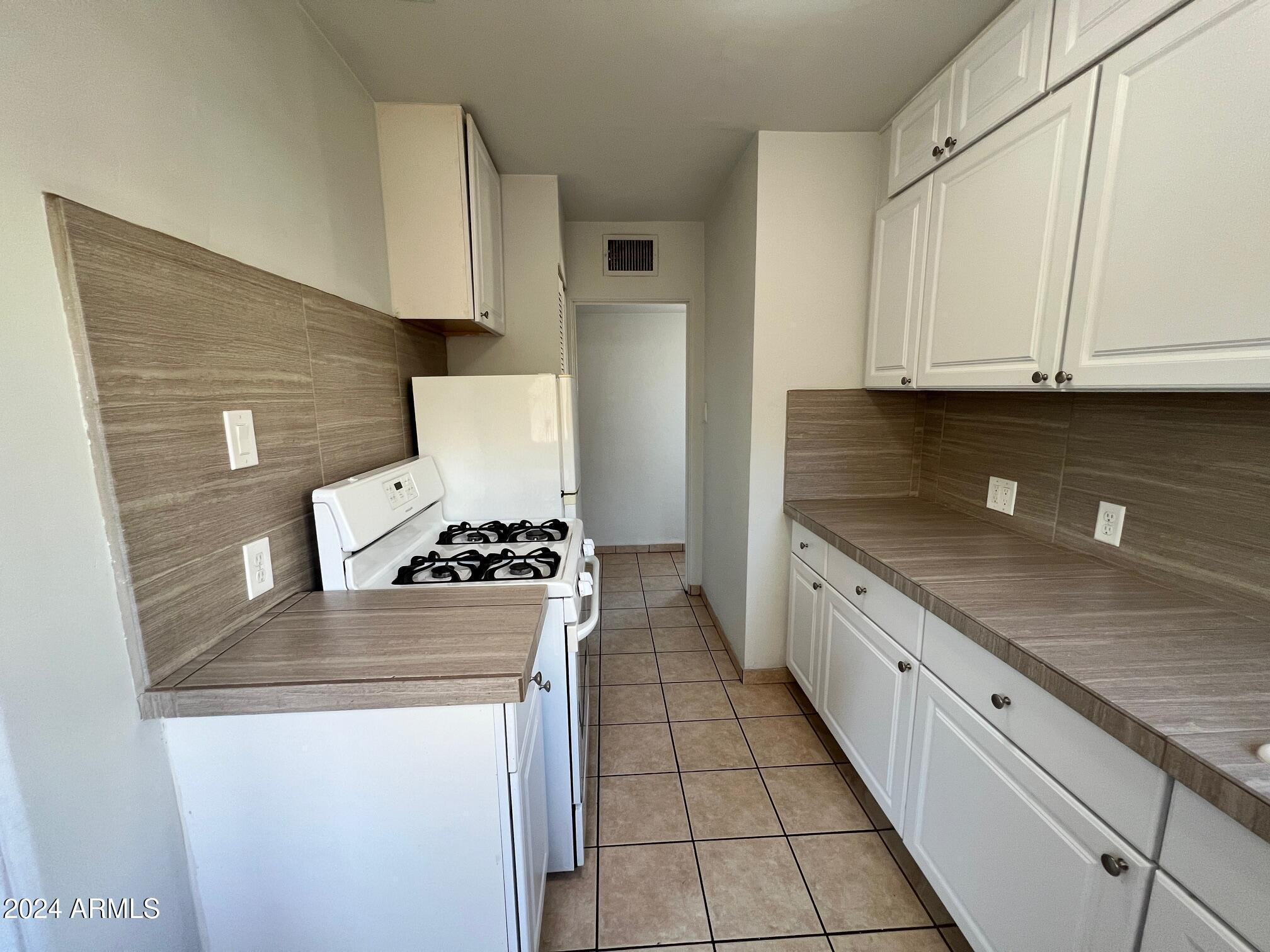 30 West Culver Street, Unit B Phoenix, AZ 85003 - Photo 12 of 36 a kitchen with granite countertop a stove sink and cabinets
