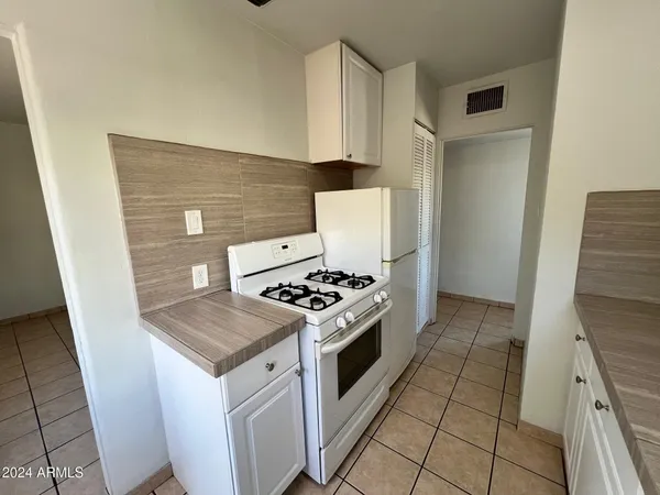a kitchen with a stove top oven and cabinets