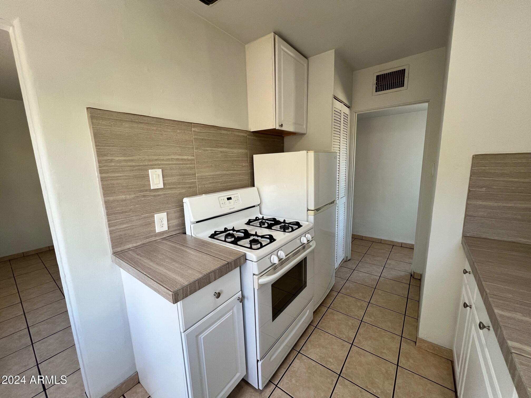 30 West Culver Street, Unit B Phoenix, AZ 85003 - Photo 13 of 36 a kitchen with a stove top oven and cabinets