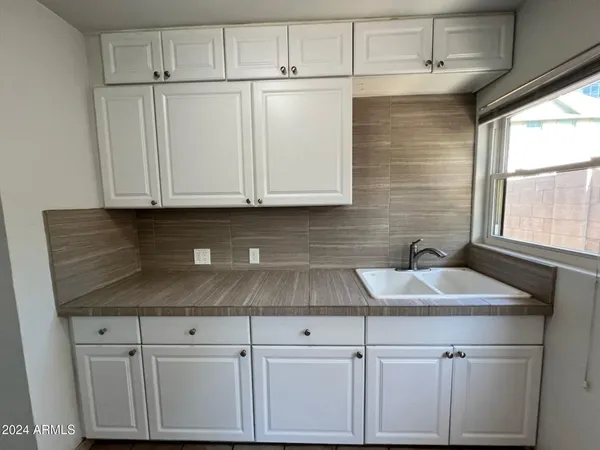 a sink with white cabinets