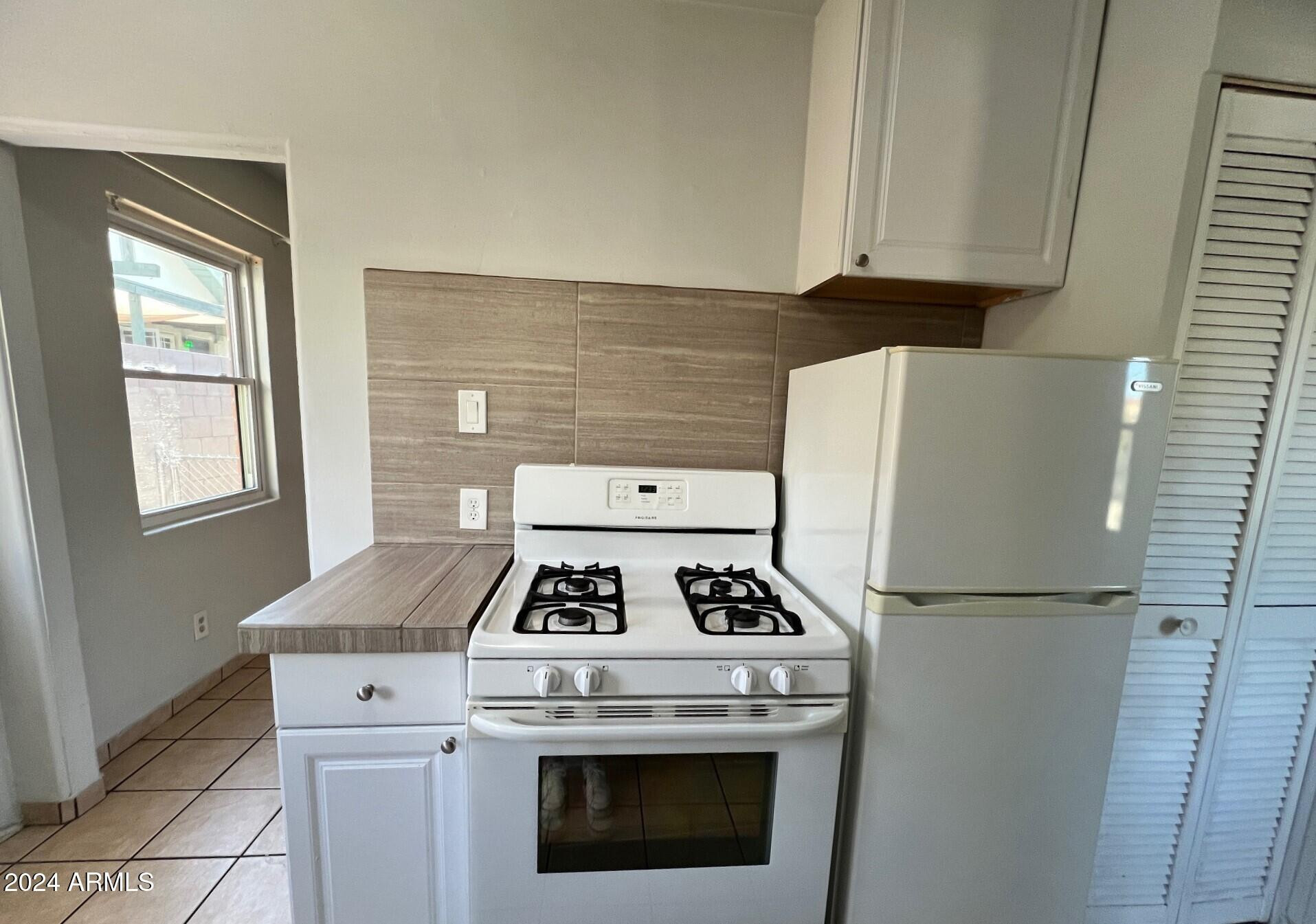 30 West Culver Street, Unit B Phoenix, AZ 85003 - Photo 14 of 36 a kitchen with a stove and white cabinets