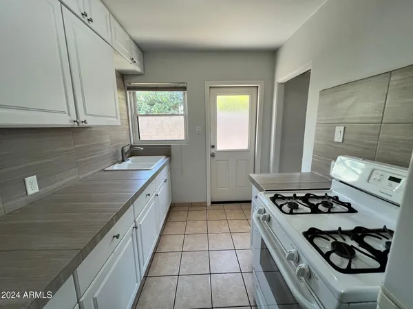 a kitchen with stainless steel appliances granite countertop a sink stove and cabinets
