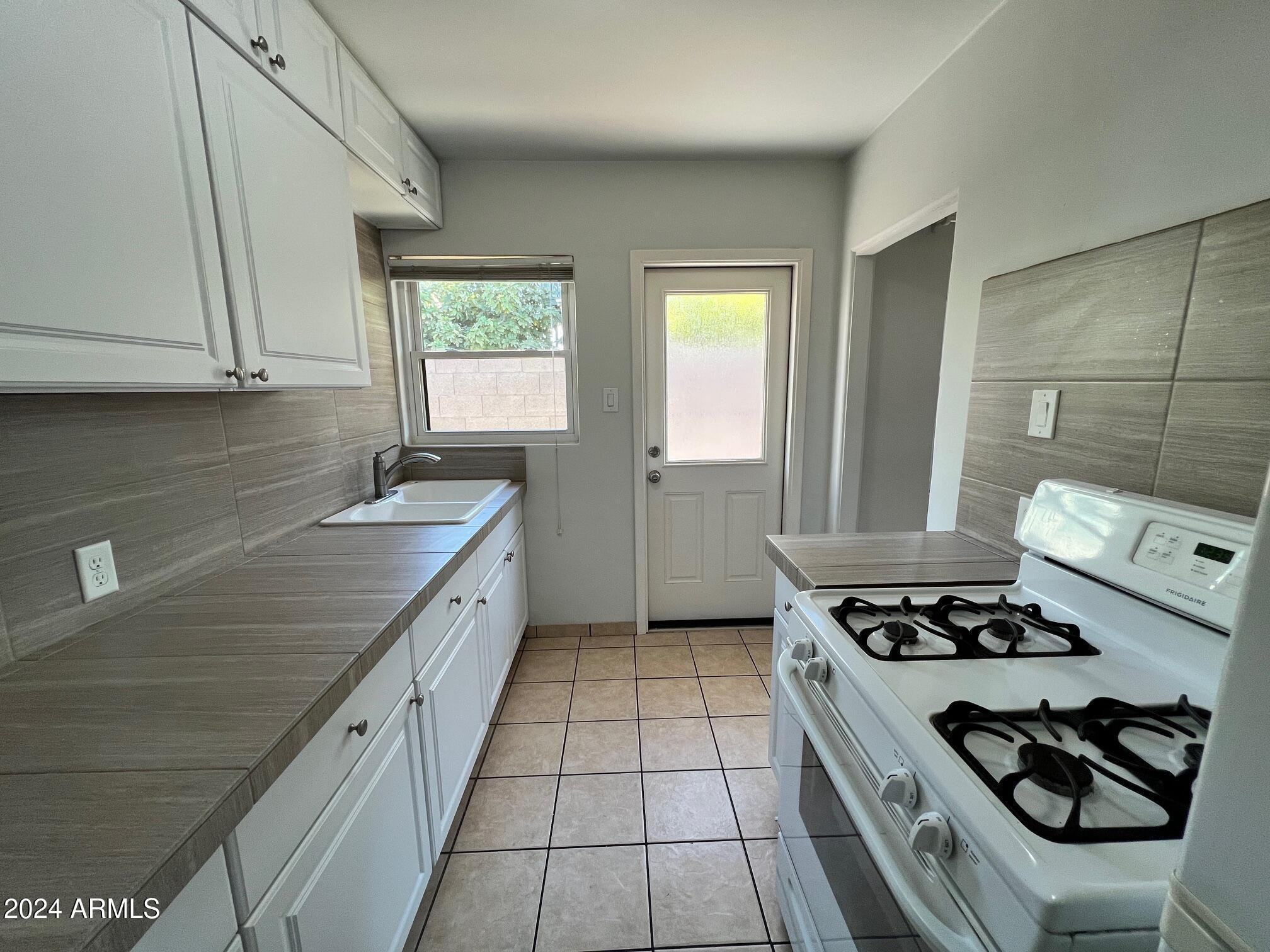 30 West Culver Street, Unit B Phoenix, AZ 85003 - Photo 16 of 36 a kitchen with stainless steel appliances granite countertop a sink stove and cabinets