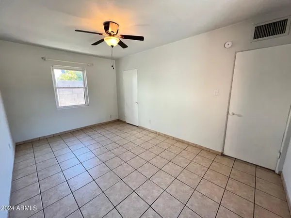 a view of an empty room and a chandelier fan