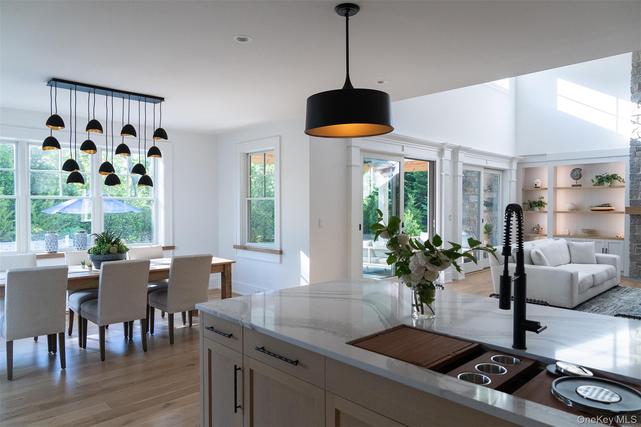 465 Ripple Water Lane Southold, NY 11971 - Photo 47 of 47 Kitchen with decorative light fixtures, light stone countertops, light wood-style flooring, open floor plan, and healthy amount of natural light