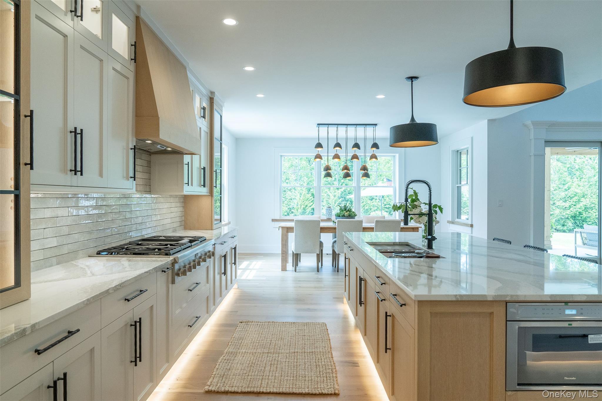 465 Ripple Water Lane Southold, NY 11971 - Photo 23 of 46 Kitchen with light stone countertops, decorative backsplash, recessed lighting, decorative light fixtures, and light wood-style flooring