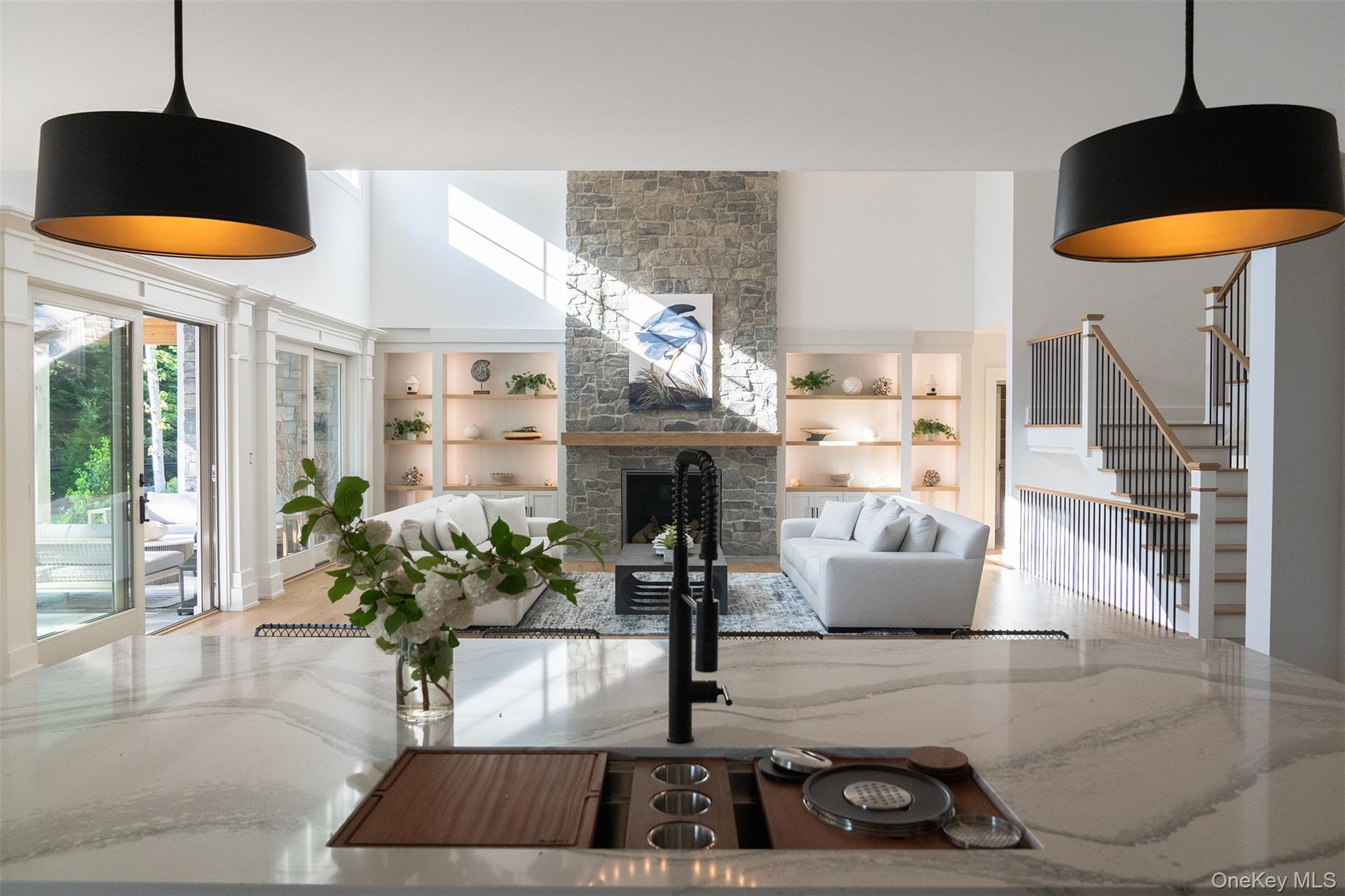 465 Ripple Water Lane Southold, NY 11971 - Photo 26 of 47 Living area with a stone fireplace, stairway, built in features, and a high ceiling