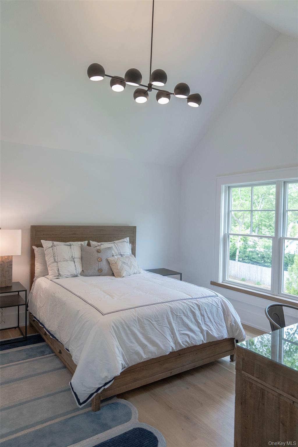 465 Ripple Water Lane Southold, NY 11971 - Photo 29 of 46 Bedroom with lofted ceiling, wood finished floors, ceiling fan, and a chandelier