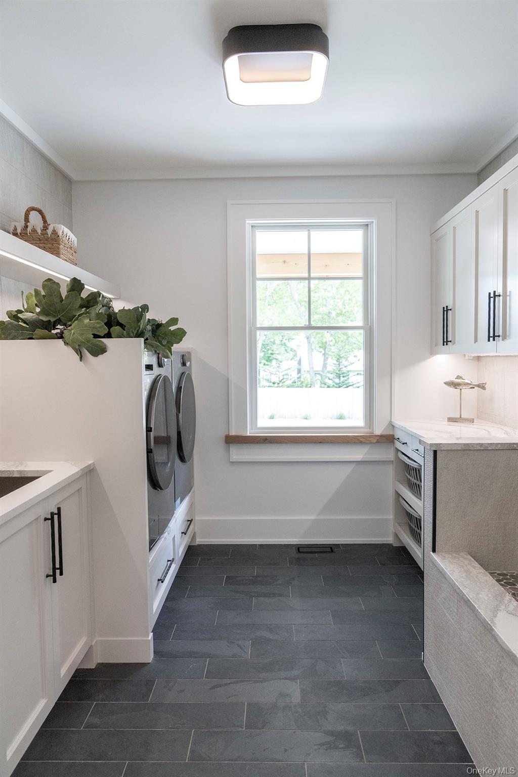 465 Ripple Water Lane Southold, NY 11971 - Photo 29 of 47 Laundry area featuring cabinet space, wood tiled floors, and washer and clothes dryer